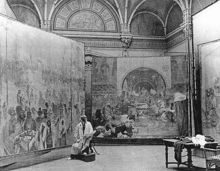 Photo de Mucha dans son atelier en 1920, entouré de trois toiles de la série L'Epopée Slave